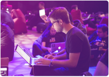 Homem utilizando um notebook em um evento de desenvolvimento.